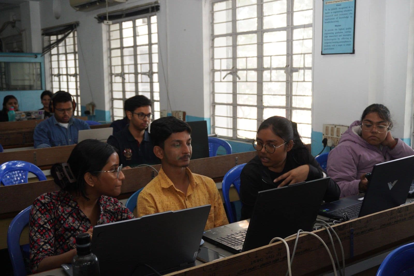 Students collaborating on laptops in a classroom